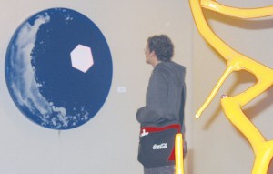 Dwelling: Ferris student David Ensing dwells on Ted Evans’ piece titled “Idle Splash.” Evans’ sculptural paintings are currently exhibited in the Rankin Art Gallery and will remain in place until mid-December. Photo By: Kristyn Sonnenberg | Photo Editor