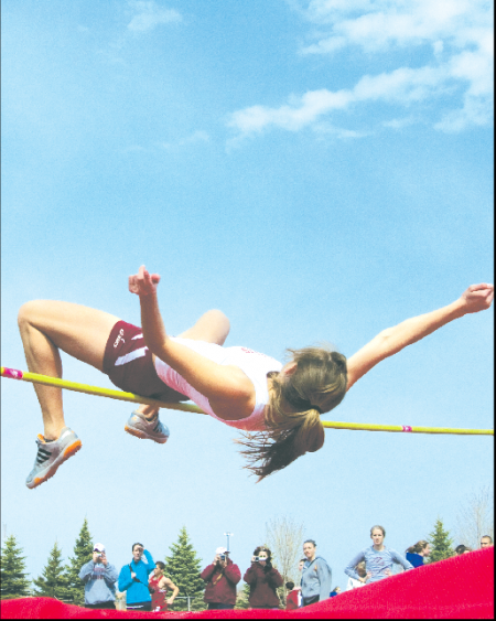 One Hurdle at a Time: Emily Cross, track senior, leaps over the high jump during a track meet. Emily took third in the 100-meter hurdles at the Northwood Invitational on Saturday April 17. Photo By: Kate Dupon | Photographer