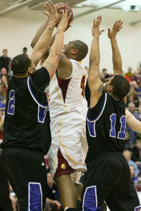 Closing the Season: Justin Keenan, senior pushes past two Grand Valley defenders during a game in the 2010-11 season. The Bulldogs had an overall record of 24-8 at the end of the season. Torch File Photo