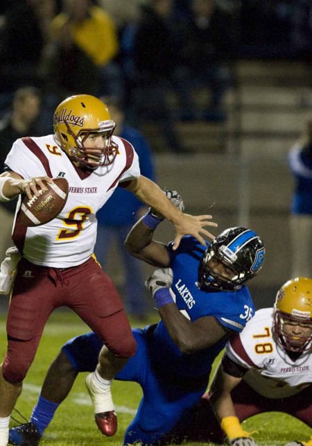 Losing the Classic: FSU senior quartback Tom Schneider scrambles over a Grand Valley defenseman during the Anchor-Bone Classic Oct. 22. The Bulldogs were defeated 57-10 by the Lakers. Photo Courtesy of Grand Valley State Athletics