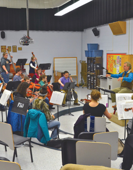 The West Central Chamber Orchestra practices under the direction of Dr. Scott Cohen for the annual Ferris and Community holiday concert. The concert, dubbed the “Symphonic Santa Sunday,” will feature a mixture of religious and secular Christmas songs and carols and even songs from “A Charlie Brown Christmas.” The concert will take place on Dec. 8 at 4 p.m. in Williams Auditorium.  Photo By: Olivia Odette | Photographer