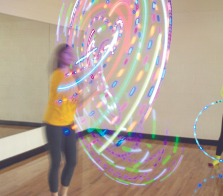 Junior psychology and pre-med junior Irma Collins practices her hoop dancing in the rec center using her light-up hoop. Irma, as well as many other students, enjoy hooping as both a from of exercise and a great stress reliever. Photo By: Melanie Ronquillo | Photographer