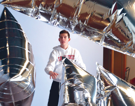 Sophomore Erik Morianti plays around with giant silver balloons at the Artworks studio in downtown Big Rapids. This interactive exhibit is inspired by Andy Warhol’s “Silver Clouds”, combining light, air, movement and audience participation. Artworks is holding the Festival of the Arts throughout the entire month of February, with exhibits focusing on music, theater, painting and sculptures. Photo By: Olivia Odette | Photographer