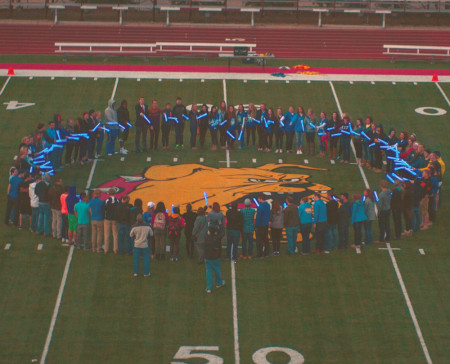 Students gather on Top Taggart field with blue lights in hand to show their support during Autism Awareness month. Photo By: Tori Thomas | Photographer