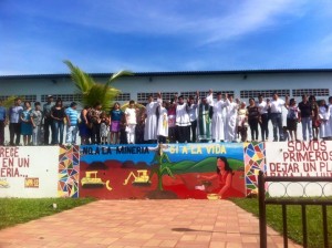 A delegation of El Salvadoreans stand together against mining efforts in the Arcatao community. Featured is a mural that reads: “Say no to mining, say yes to life.”
