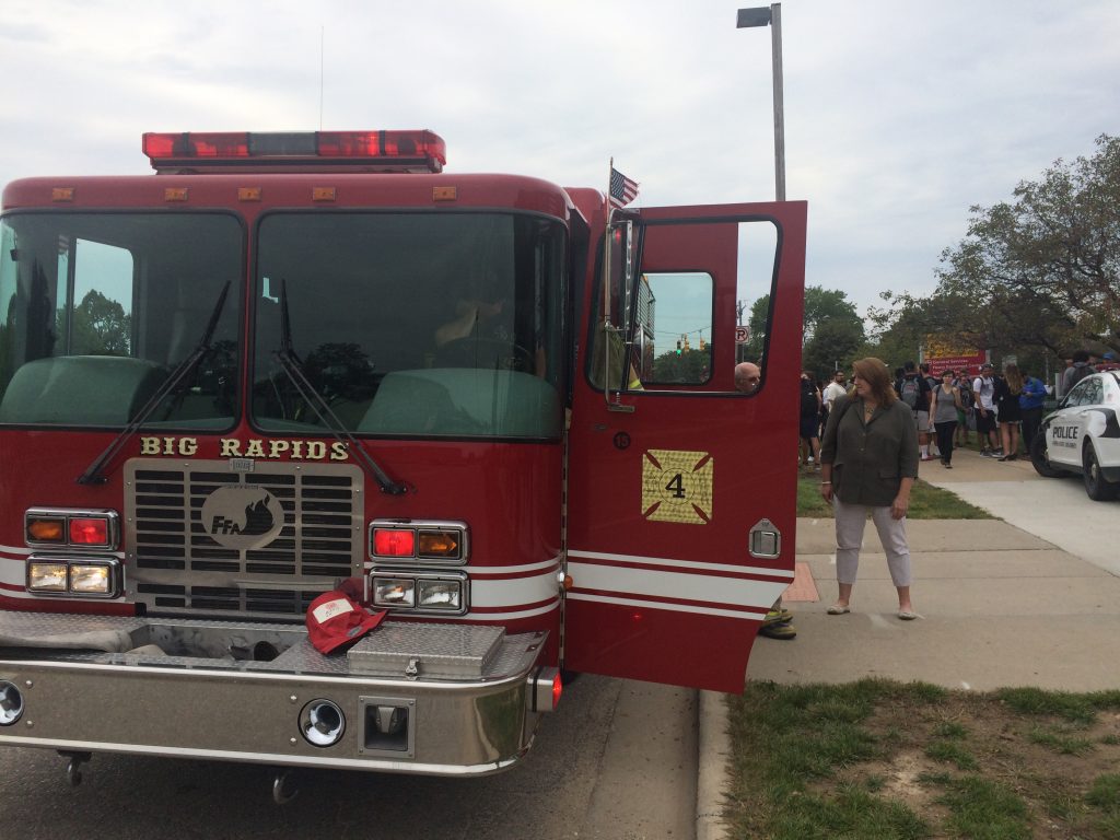 Students and fire trucks in front of the College of Business following an evacuation. 